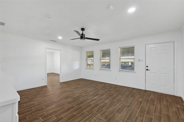 unfurnished living room featuring crown molding, ceiling fan, and dark wood-type flooring