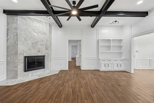 unfurnished living room with coffered ceiling, ceiling fan, hardwood / wood-style flooring, beamed ceiling, and a fireplace