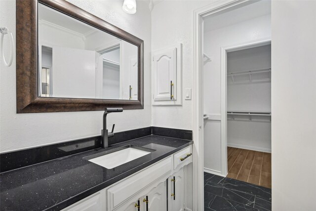 bathroom featuring hardwood / wood-style floors, vanity, and ornamental molding