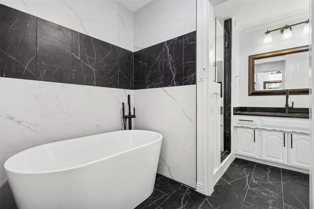 bathroom featuring vanity, tile walls, and shower with separate bathtub