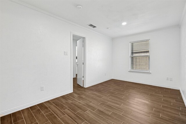 spare room featuring dark hardwood / wood-style floors and crown molding