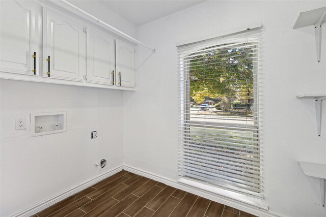 clothes washing area with washer hookup, plenty of natural light, dark hardwood / wood-style flooring, and cabinets