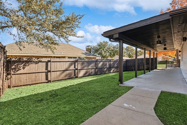 view of yard with ceiling fan and a patio