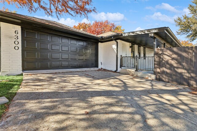 view of side of property featuring covered porch and a garage