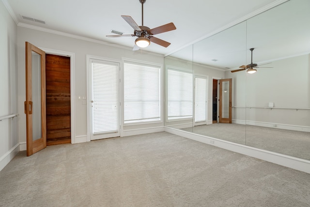 carpeted empty room with plenty of natural light, ornamental molding, and ceiling fan