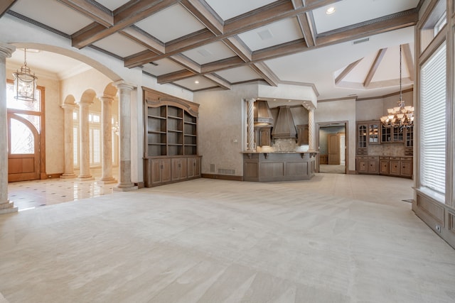 unfurnished living room with light carpet, an inviting chandelier, ornate columns, and coffered ceiling