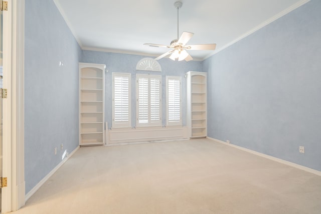 empty room with ceiling fan, light colored carpet, and crown molding