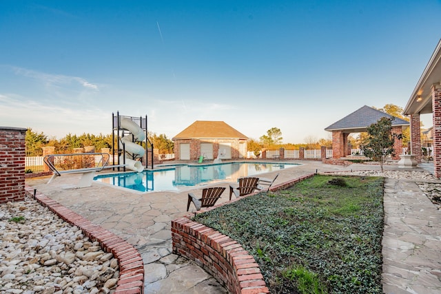 view of swimming pool featuring a patio area and a water slide