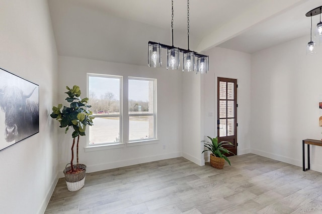 dining room featuring beam ceiling and light wood-type flooring