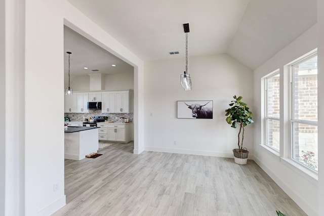 interior space with light hardwood / wood-style floors and lofted ceiling