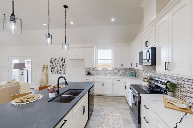 kitchen featuring appliances with stainless steel finishes, sink, pendant lighting, light hardwood / wood-style flooring, and white cabinets