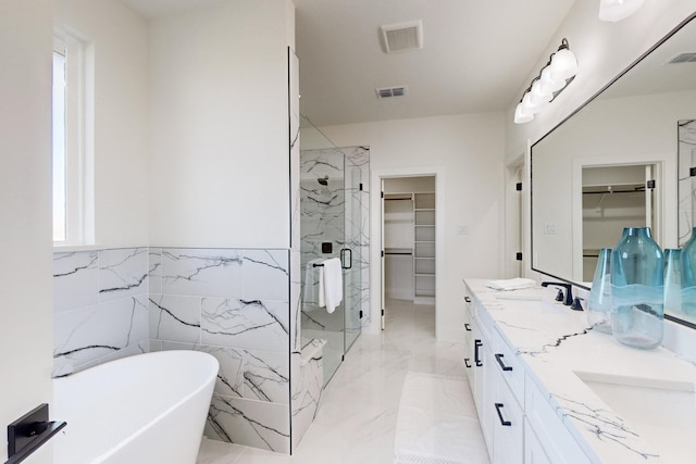 bathroom with vanity, separate shower and tub, and tile walls