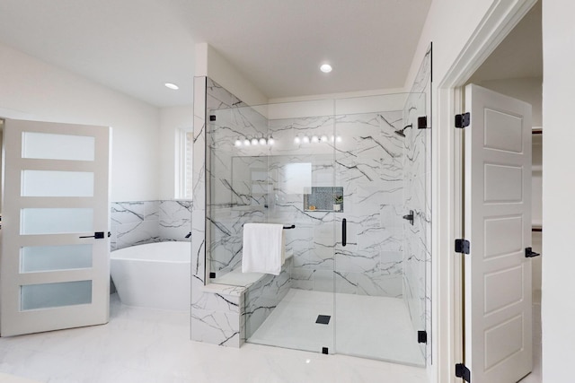 bathroom featuring separate shower and tub and tile walls