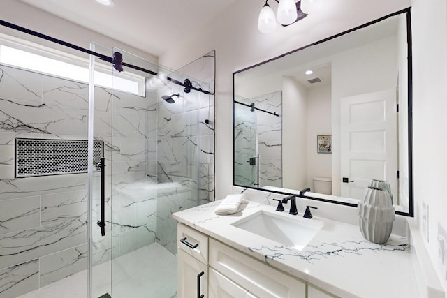 bathroom featuring vanity, toilet, and walk in shower