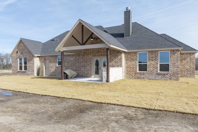 back of property featuring a lawn and a patio