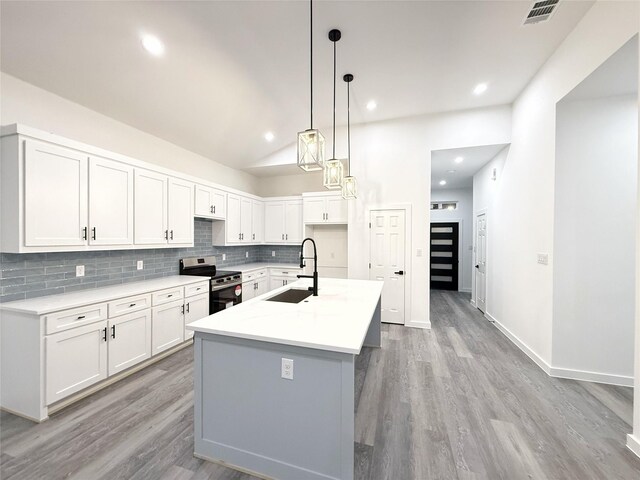 kitchen with stainless steel range with electric stovetop, white cabinets, sink, an island with sink, and light hardwood / wood-style floors