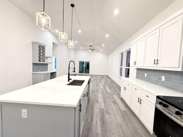 kitchen featuring a spacious island, sink, electric range, ceiling fan, and decorative light fixtures