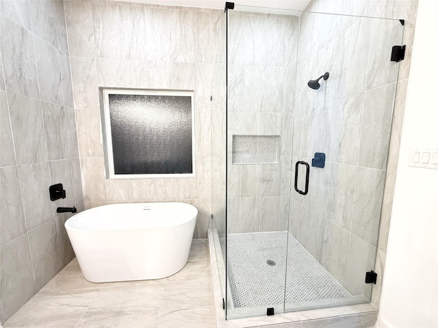 bathroom with separate shower and tub and tile walls