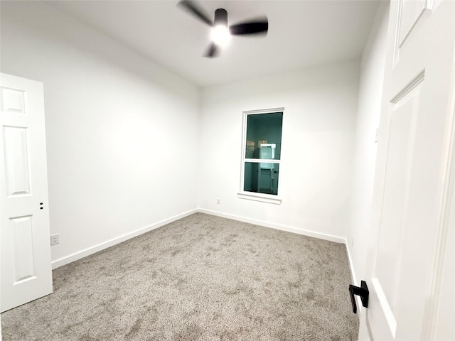 unfurnished room with ceiling fan and carpet