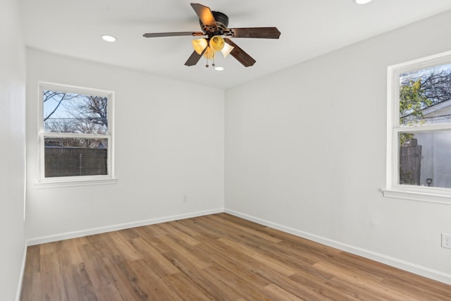 unfurnished room with wood-type flooring, a wealth of natural light, and ceiling fan