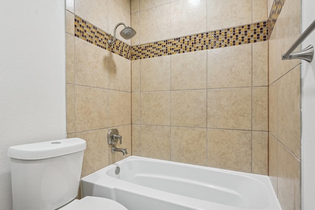 bathroom featuring tiled shower / bath combo and toilet