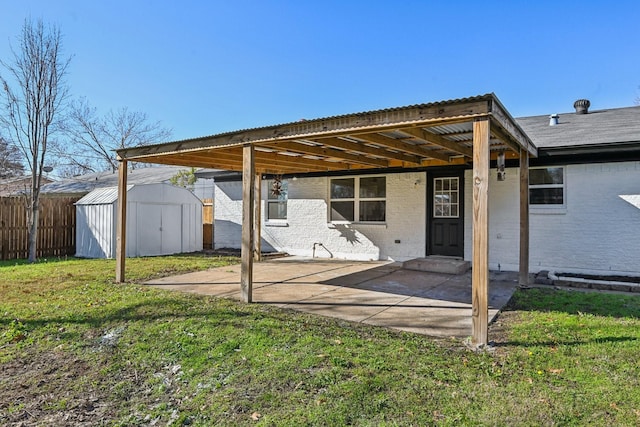 rear view of property with a lawn, a patio, and a storage shed