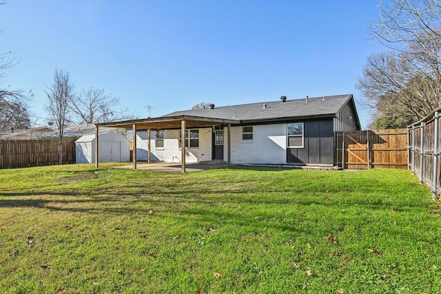 rear view of house featuring a yard, a storage unit, and a patio area