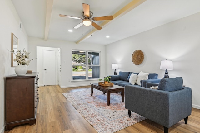 living room with beamed ceiling, ceiling fan, and light wood-type flooring