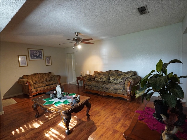 living room with wood-type flooring, a textured ceiling, and ceiling fan