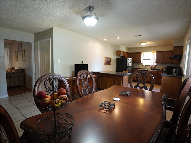 dining space featuring light tile patterned floors and a textured ceiling