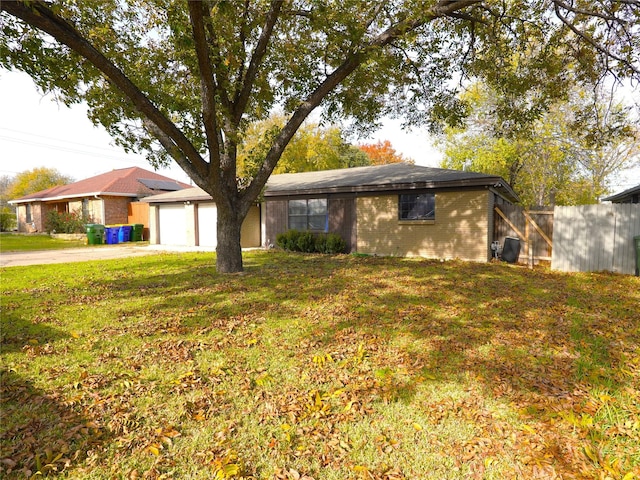 ranch-style house featuring a garage and a front lawn