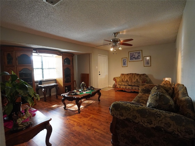 living room with ceiling fan, hardwood / wood-style floors, and a textured ceiling