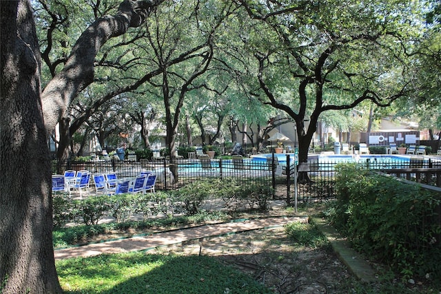 view of home's community with fence and a pool