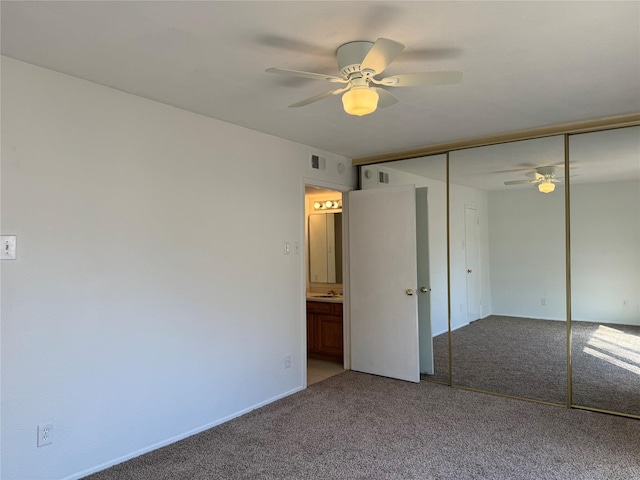 unfurnished bedroom featuring carpet, sink, a closet, and ceiling fan