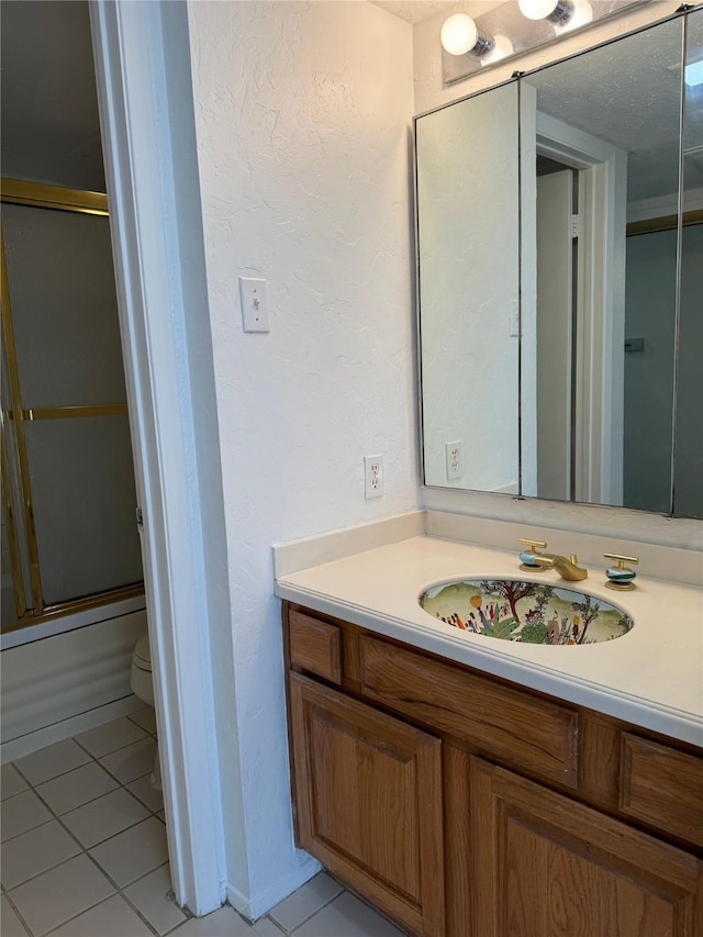 full bathroom with tile patterned flooring, vanity, toilet, and enclosed tub / shower combo