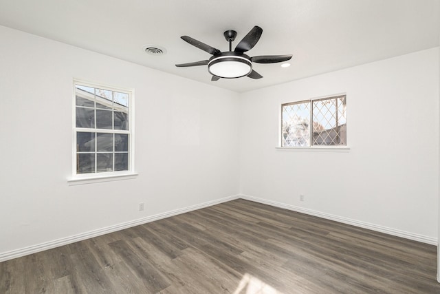 unfurnished room featuring dark hardwood / wood-style flooring, ceiling fan, and a healthy amount of sunlight