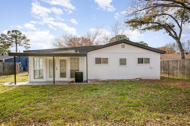 back of house featuring a lawn and french doors