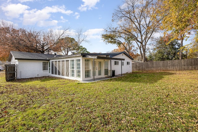 back of house featuring a patio area, a sunroom, and a yard