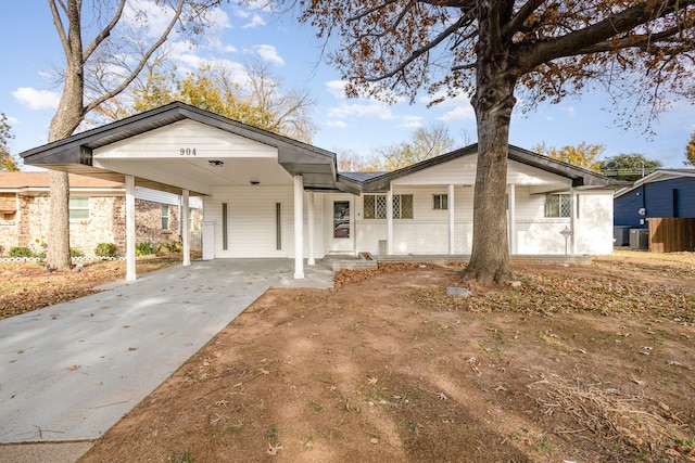 view of front of house featuring covered porch, central AC, and a carport