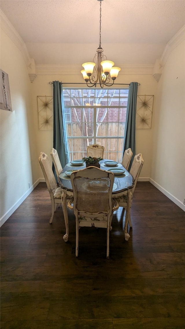 dining space featuring dark hardwood / wood-style flooring, ornamental molding, and a notable chandelier