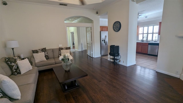 living room with wood-type flooring, ceiling fan, crown molding, and sink