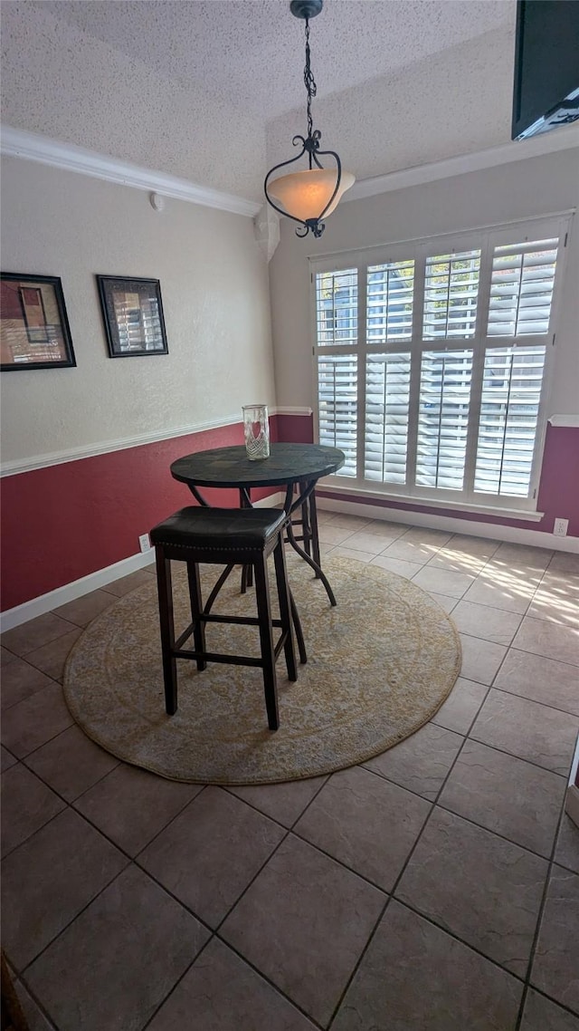 tiled dining room with crown molding and a textured ceiling