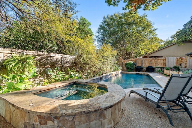 view of pool with an in ground hot tub