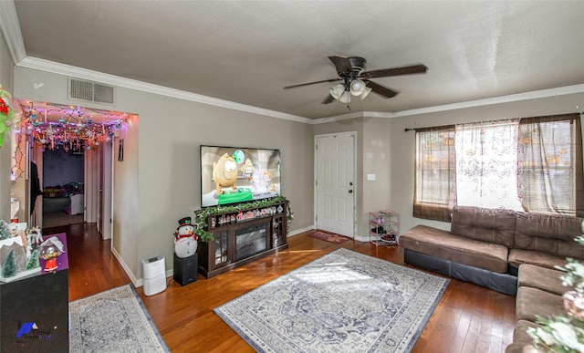 living room featuring dark hardwood / wood-style flooring, ceiling fan, and ornamental molding