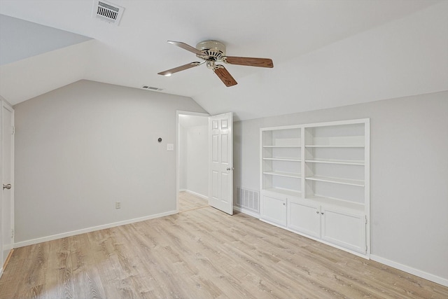 additional living space with built in shelves, light hardwood / wood-style floors, ceiling fan, and vaulted ceiling