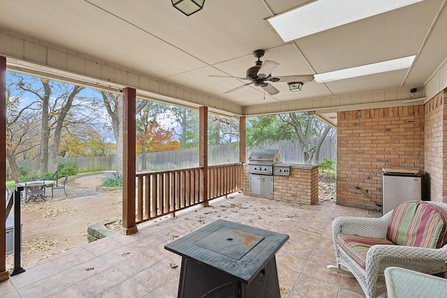 view of patio featuring ceiling fan, area for grilling, and exterior kitchen