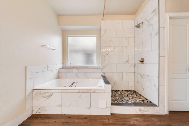 bathroom featuring wood-type flooring and shower with separate bathtub