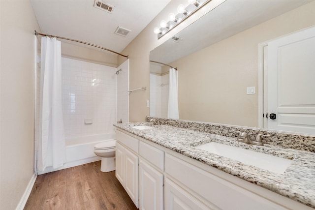 full bathroom with vanity, hardwood / wood-style floors, shower / tub combo, and toilet