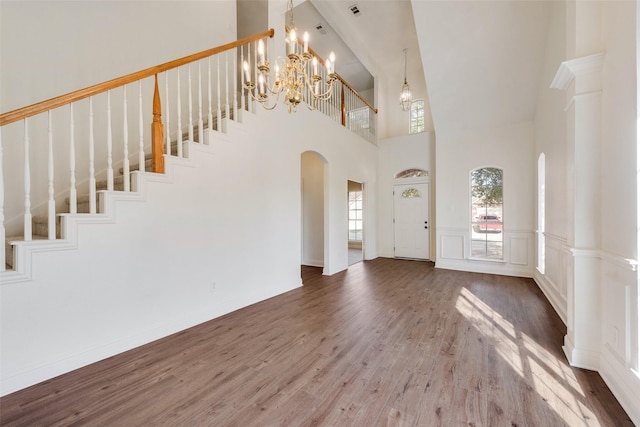 entrance foyer with a high ceiling, wood-type flooring, and a chandelier