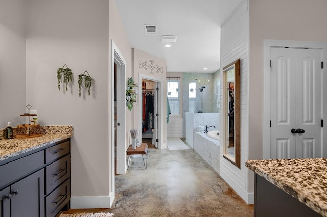 bathroom featuring plus walk in shower, vanity, and concrete flooring